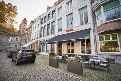 a car parked on a street next to buildings at Saillant Hotel Maastricht City Centre - Auping Hotel Partner in Maastricht