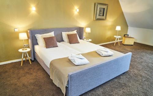 een slaapkamer met een groot bed en 2 handdoeken bij Saillant Hotel Maastricht City Centre - Auping Hotel Partner in Maastricht