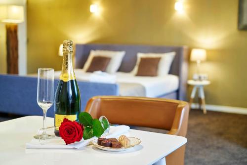 a table with a bottle of champagne and a plate of food at Saillant Hotel Maastricht City Centre - Auping Hotel Partner in Maastricht
