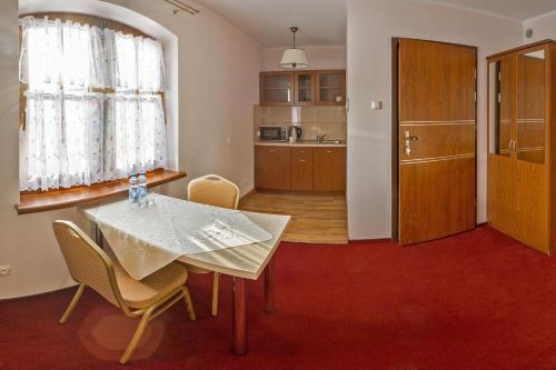 a kitchen and dining room with a table and chairs at Ranczo w Dolinie - Bałtów in Bałtów