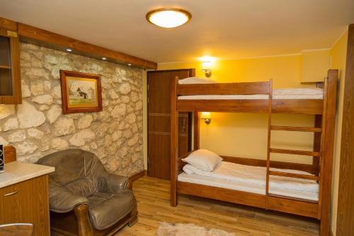 a room with two bunk beds and a chair at Ranczo w Dolinie - Bałtów in Bałtów