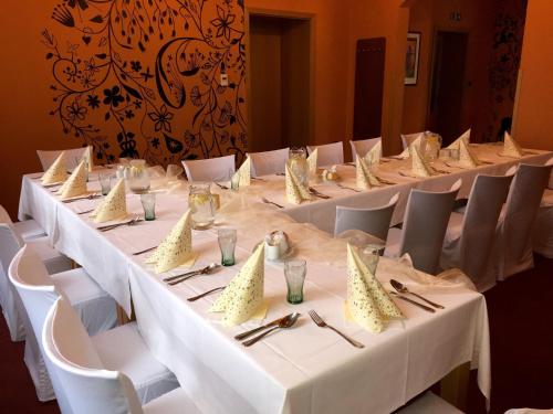 a group of tables with white tablecloths and napkins at Hotel Hron in Náchod