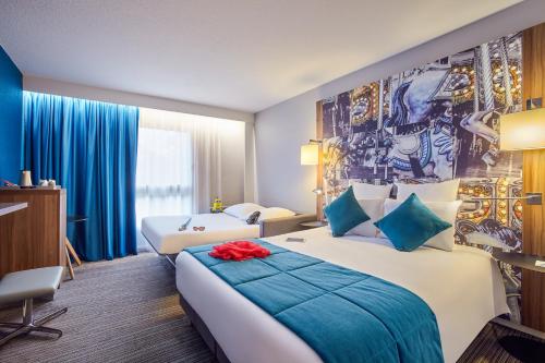 a hotel room with two beds and a mural on the wall at Hotel Mercure Château de Fontainebleau in Fontainebleau