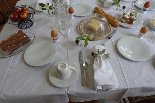 een witte tafel gedekt met witte borden en bestek bij Château Moussoulens in Moussoulens