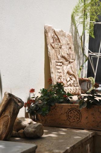 a stone statue sitting on a ledge with flowers at Sibel Hotel in Antalya