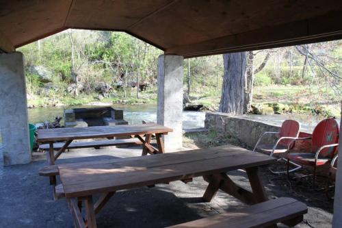 two picnic tables and chairs in a building with a fire pit at Qualla Cabins and Motel Cherokee near Casino in Whittier