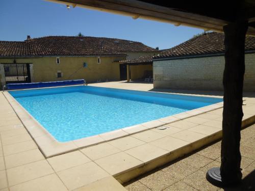 a swimming pool with blue water in a yard at L'Ancienne Distillerie in Segonzac