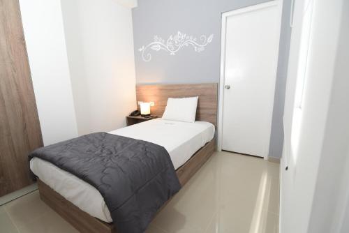 a small bedroom with a bed and a mirror at Escala Urban Hotel in Chiclayo