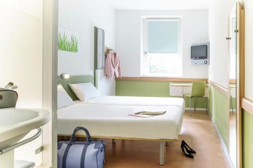 a bedroom with a bed and a dresser at ibis budget Berlin Alexanderplatz in Berlin