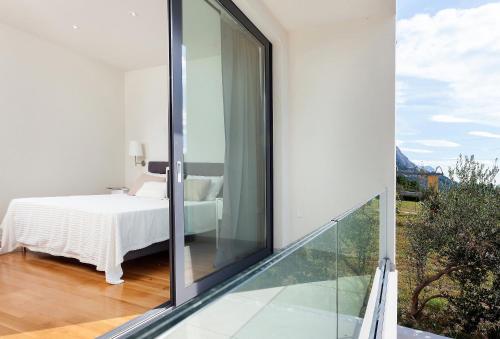 a room with a bed and a glass balcony at Villa Sima in Makarska