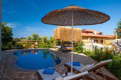a swimming pool with an umbrella and lounge chairs and a swimming pool at Mandarin & Mango Boutique Hotel in Faralya