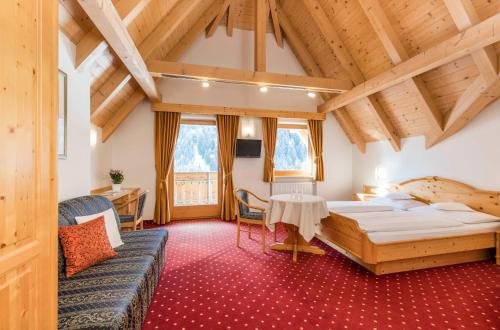 una camera d'albergo con letto e tavolo di B&B Hotel Alpenrose Rooms & Apartments a Valles