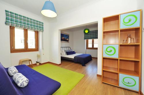 Cosy Bedrooms Guest House في لشبونة: غرفة معيشة مع أريكة زرقاء وسرير