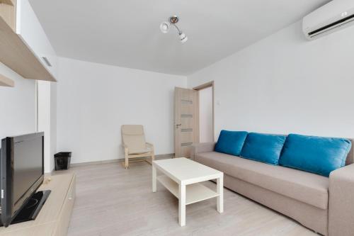 ein Wohnzimmer mit einem Sofa und einem TV in der Unterkunft Summer Fun in Constanţa