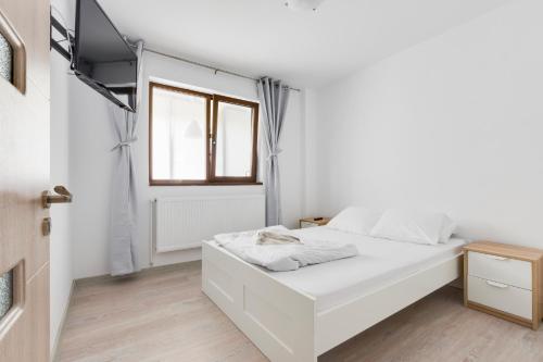 a white bedroom with a bed and a window at Summer Fun in Constanţa
