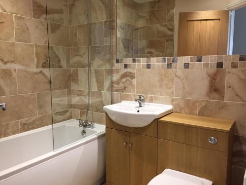 a bathroom with a sink and a tub and a toilet at Fir Tree Barn in Pollington