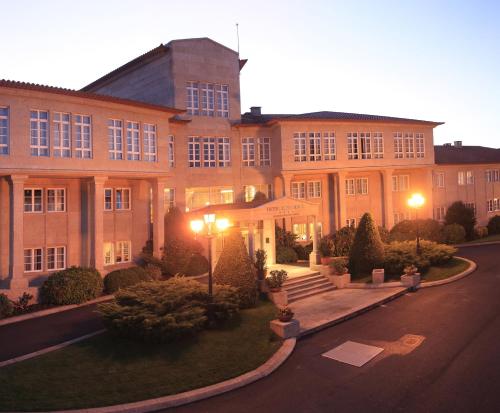 a large brick building with lights on at Gran Hotel Los Abetos in Santiago de Compostela