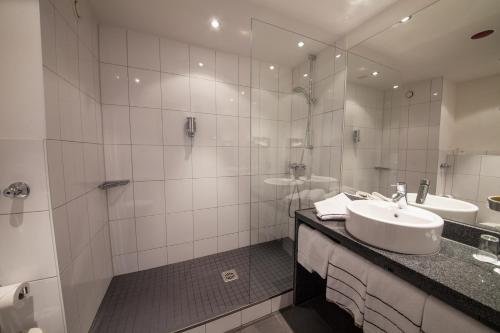 a bathroom with a sink and a shower at Novina Hotel Tillypark in Nürnberg