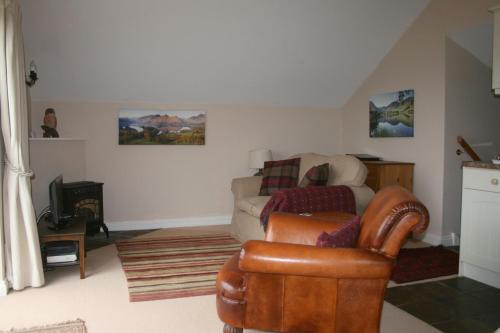 uma sala de estar com um sofá e uma cadeira em StoneyGill A em Keswick