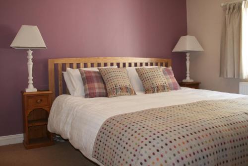 ein Schlafzimmer mit einem Bett mit Kissen und zwei Lampen in der Unterkunft StoneyGill A in Keswick