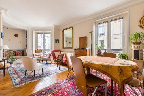 a living room with a table and chairs at Veeve - Overlooking the Seine on Ile de la Cité in Paris