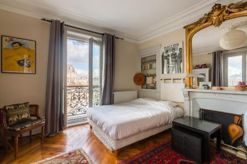 - une chambre avec un lit, une cheminée et une fenêtre dans l'établissement Veeve - Overlooking the Seine on Ile de la Cité, à Paris