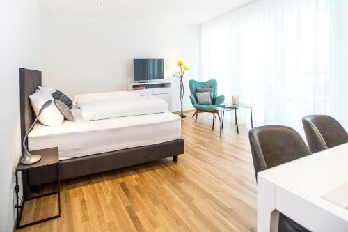 1 dormitorio con 1 cama, mesa y sillas en Ferienwohnung Höchsten, en Friedrichshafen