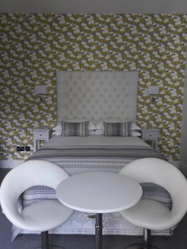 a bedroom with a large bed with two white tables at Coast B&B in Bexhill