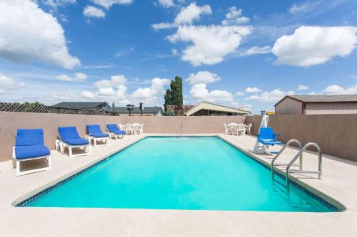 a swimming pool with lounge chairs and a swimming pool at Travelodge by Wyndham Williams Grand Canyon in Williams