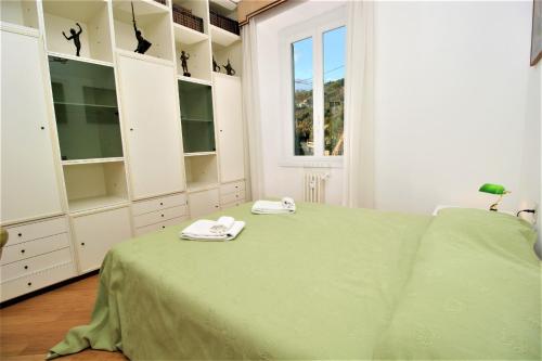 a bedroom with a green bed and white cabinets at Eden by PortofinoHomes in Santa Margherita Ligure