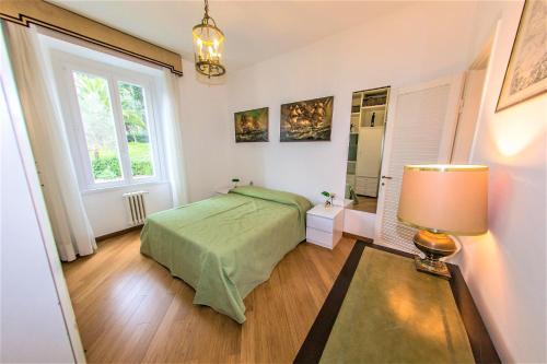 a bedroom with a green bed and a window at Eden by PortofinoHomes in Santa Margherita Ligure