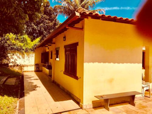 a yellow and white building with a bench next to it at Margem da Lagoa Santa in Lagoa Santa