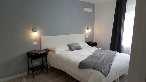a bedroom with a white bed with two night stands at Altebas in Nogaredo di Prato