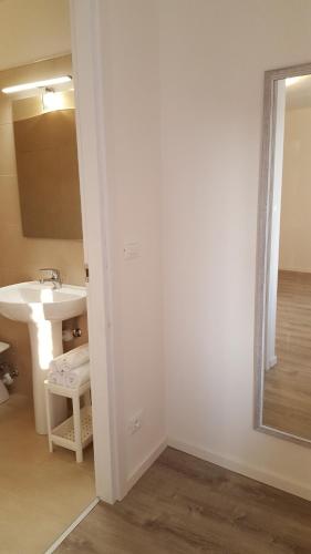 a white bathroom with a sink and a mirror at Altebas in Nogaredo di Prato