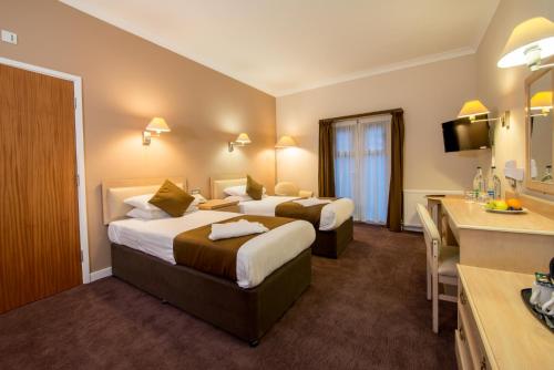 a hotel room with two beds and a sink at The Regency Hotel in Solihull