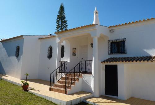 une maison blanche avec un escalier dans une cour dans l'établissement Villa Tara Christina, à Carvoeiro