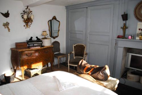 uma sala de estar com uma cama e uma lareira em Maison de village sur la route du cidre em Cambremer