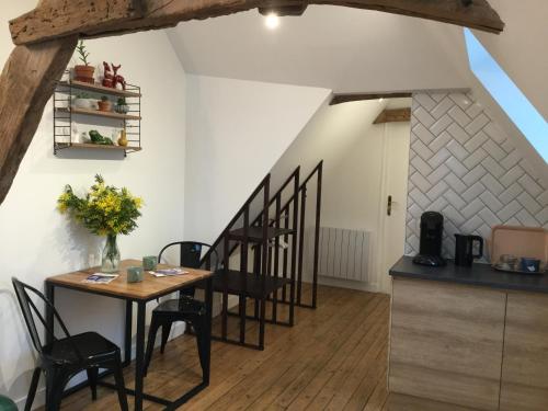 una cucina e una sala da pranzo con tavolo e sedie di La Tour Bayeux a Bayeux