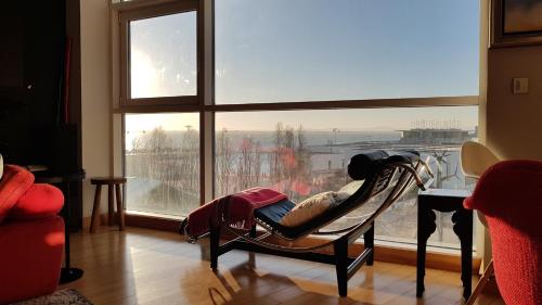 a room with a chair in front of a large window at LxRiverside Suite Apartment in Lisbon