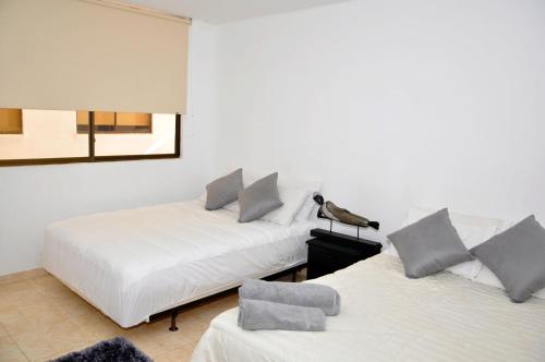two beds sitting next to each other in a room at Hotel Axis Inn By GEH Suites in Santa Marta