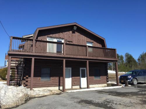 a log cabin with a balcony and a car at Mill House Market in Pulaski
