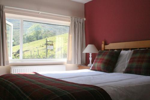 a bedroom with a bed and a large window at StoneyGill B in Keswick