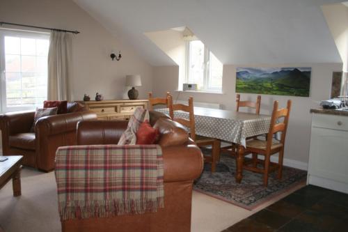 ein Wohnzimmer mit einem Sofa und einem Tisch in der Unterkunft StoneyGill B in Keswick