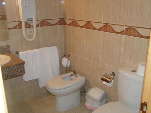 y baño con aseo y lavamanos. en Hotel Costa Verde, en Villadesuso