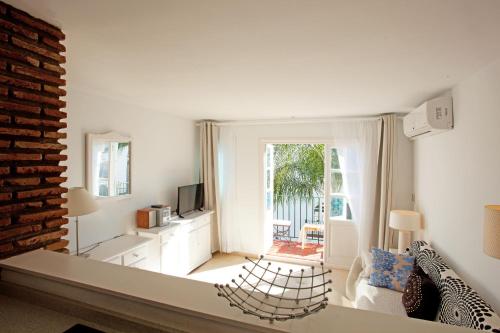 een woonkamer met een bank en een televisie bij Benavista Studio in Estepona