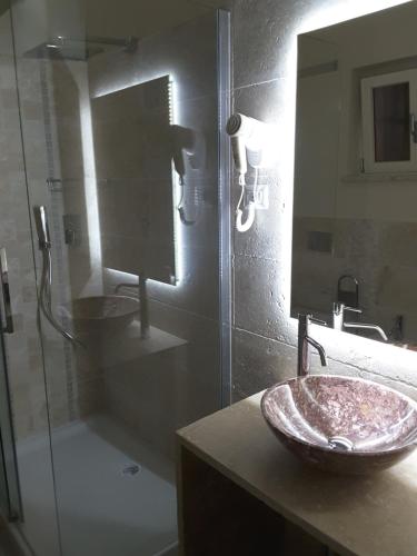 a bathroom with a sink and a glass shower at Borgo di Santa Barbara in Santa Domenica