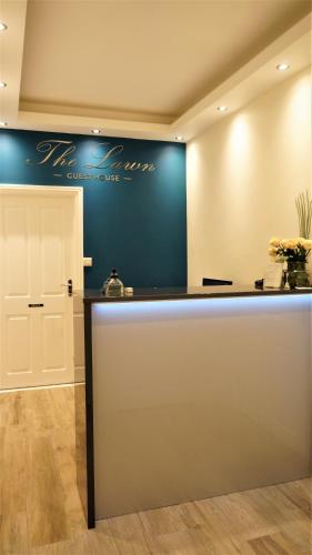 a counter in a room with a blue wall at The Lawn Guest House Gatwick in Horley