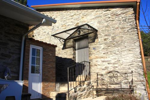 a stone building with a bench next to a door at Casa da Passagem in Vila Real