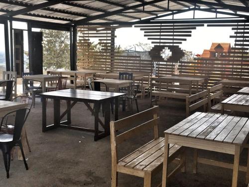 Tendo Glamping في تيبوزتلان: مطعم فارغ بطاولات وكراسي خشبية