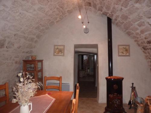 a dining room with a table and a room with a ceiling at Le Passé Composé in Millau